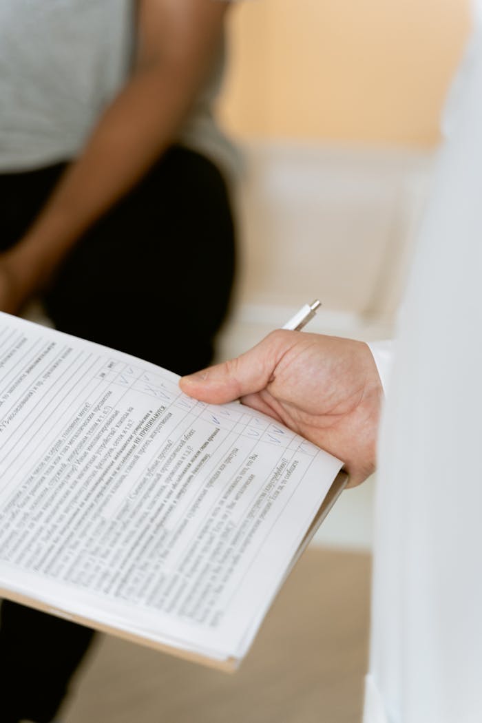 A healthcare professional reviewing a patient's medical chart during a consultation.